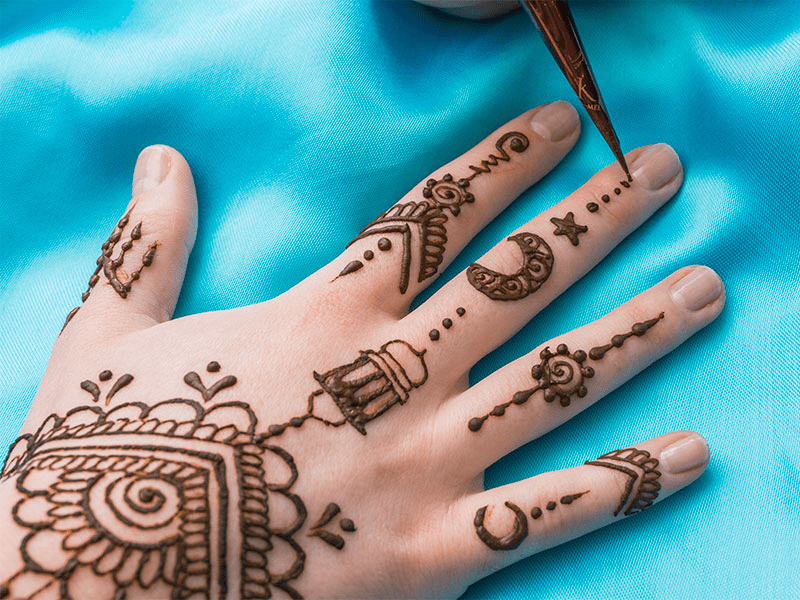 Step by step mehndi application process showing careful design planning