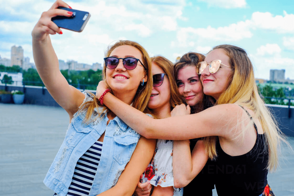 Friends capturing memories together on a smartphone for social media