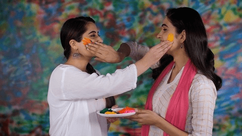 Friends applying gulal and greeting each other during Holi celebrations